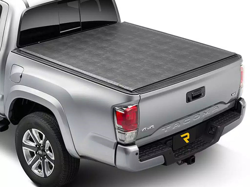 Sentry hard roll-up tonneau cover closed and latched over a silver pickup bed, rear three-quarter view