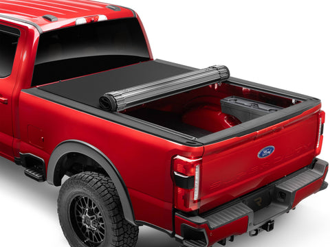 TruXedo Sentry CT hard roll-up tonneau cover partly rolled toward the cab on a red pickup, rear three-quarter view