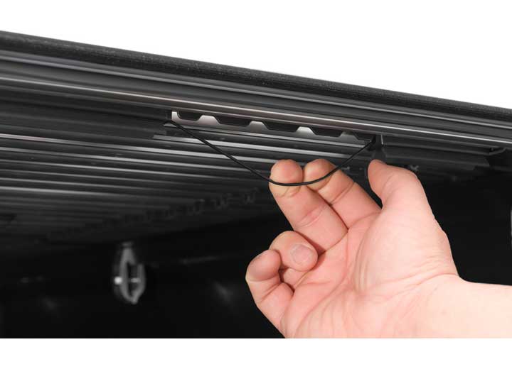 Close-up of the release lever at the rear corner on a TruXedo Sentry CT hard roll-up tonneau cover