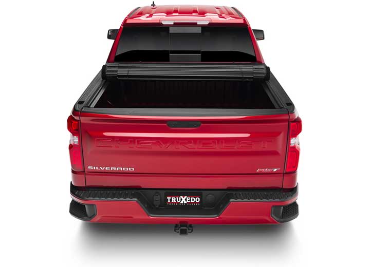 TruXedo Sentry CT hard roll-up tonneau cover rolled partway open over the bed of a pickup truck, straight rear view
