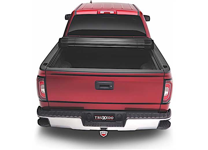 TruXedo Sentry CT hard roll-up tonneau cover rolled partway open over the bed of a pickup truck, straight rear view