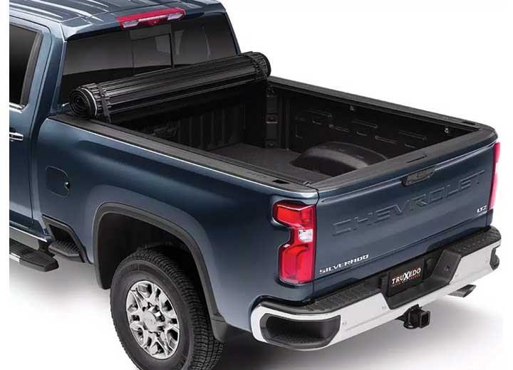 TruXedo Sentry hard roll-up tonneau cover rolled forward to the cab over the bed of a pickup truck, rear three-quarter view
