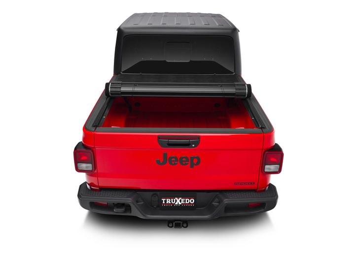TruXedo Sentry hard roll-up tonneau cover rolled partway open over the bed of a pickup truck, straight rear view