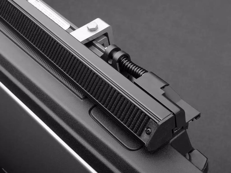 Close-up of the TruXport rolled cover resting on the side rail beside the rail clamp and its tension adjuster