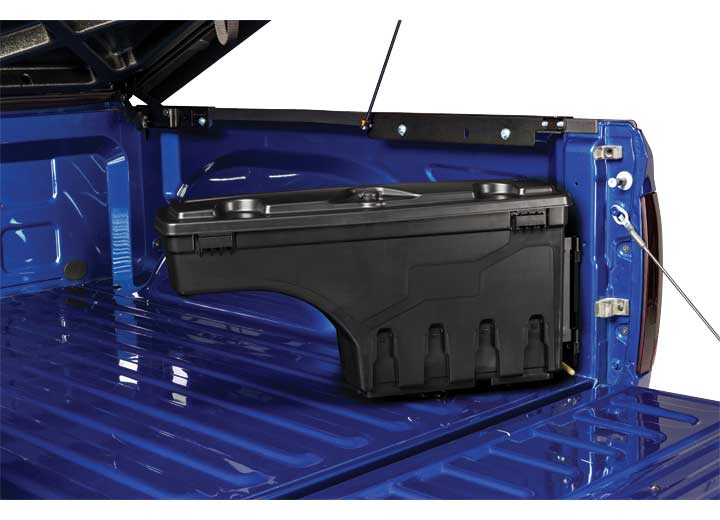 UnderCover SwingCase toolbox closed against the inner bed side panel of a blue pickup bed, seen along the length of the bed