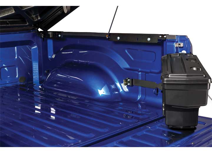 UnderCover SwingCase toolbox swung out of the bed and over the lowered tailgate with the lid still closed, mounting brackets visible on the bed side