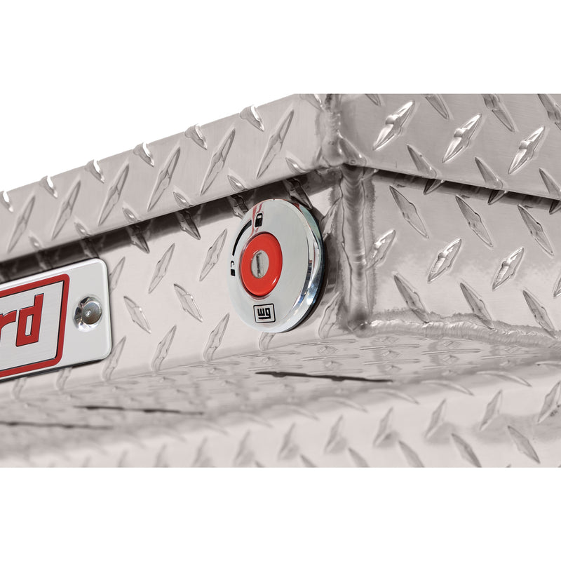 Weather Guard 121-0-04 crossover saddle box in bright aluminum diamond plate, close-up of the red push-button lock and Weather Guard badge