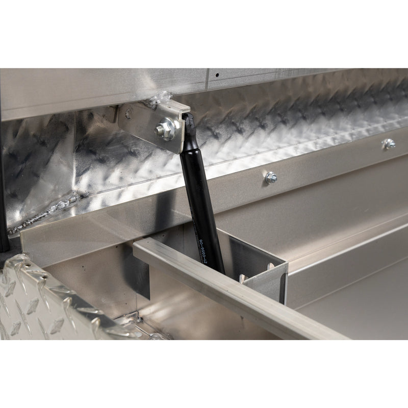 Weather Guard 127-0-04 crossover saddle box in bright aluminum diamond plate, close-up of the gas strut holding the lid open