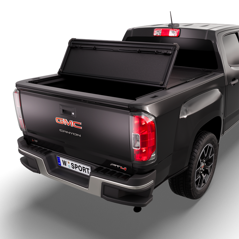 Worksport NEXUS hard folding tonneau cover on a pickup: 3D studio render of a black GMC Canyon from the rear quarter with a black NEXUS hard folding tonneau cover rear panel folded forward, one fold, rear of the bed open
