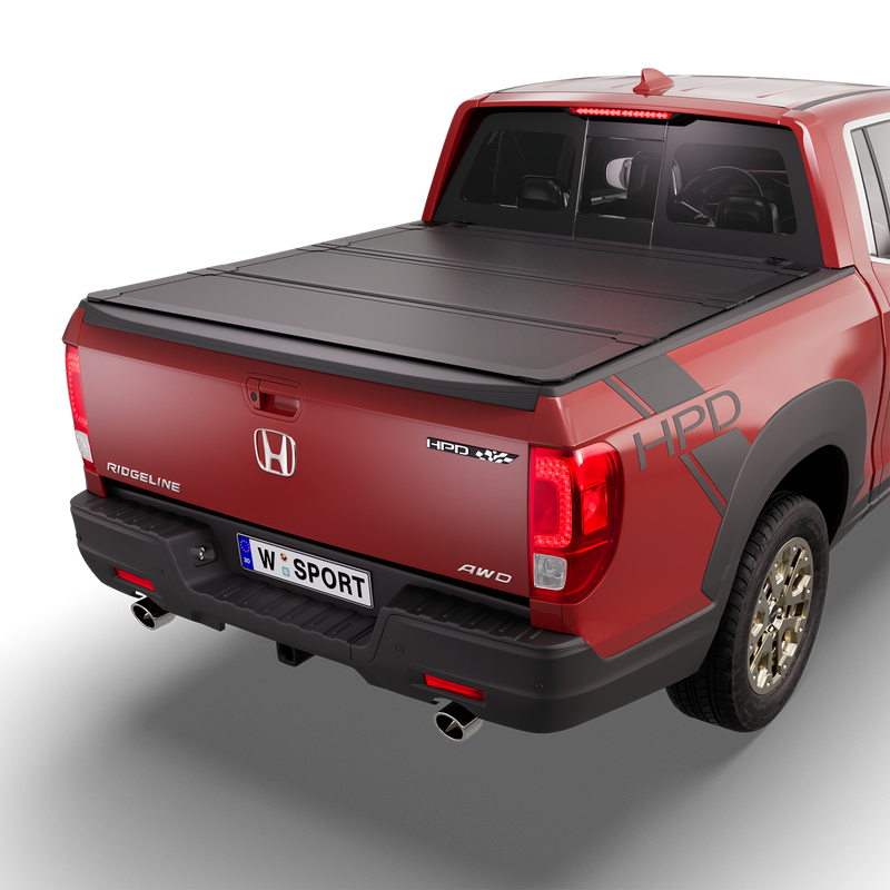 Worksport NEXUS hard folding tonneau cover on a pickup: 3D studio render of a red Honda Ridgeline from the rear quarter with a black NEXUS hard folding tonneau cover closed, all three panels flat over the bed