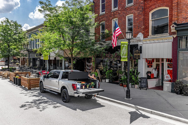 Silver 2024 Ford F-150 parked downtown with a BAKFlip MX4 hard folding tonneau cover