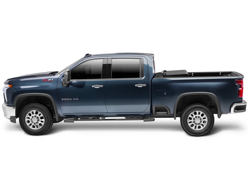 UnderCover Flex hard folding tonneau cover part-open with the middle and rear panels folded forward onto the front panel, full side profile showing the rear two-thirds of the bed exposed.