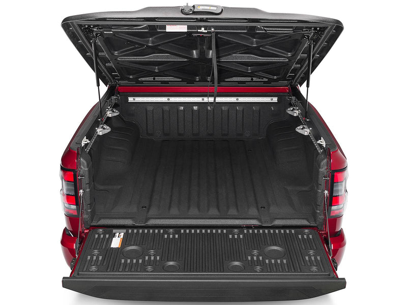 UnderCover Elite one-piece tonneau cover raised with the tailgate down, straight rear view looking the full length of the empty bed.