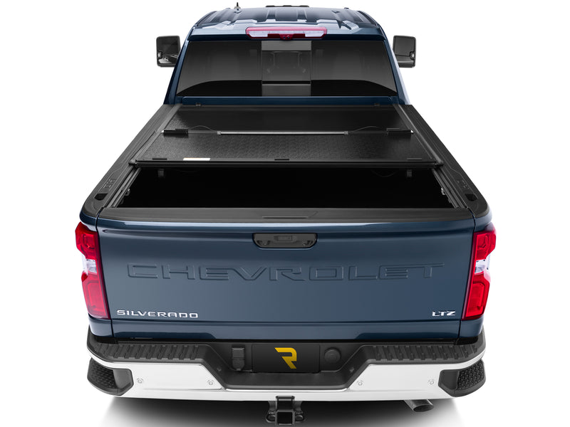 UnderCover Flex hard folding tonneau cover part-open with the rear panel folded forward, straight rear view across the full bed width.