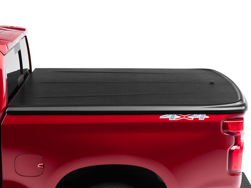 UnderCover SE one-piece tonneau cover closed on a pickup bed, side view with the whole lid in frame and the cab out of shot.