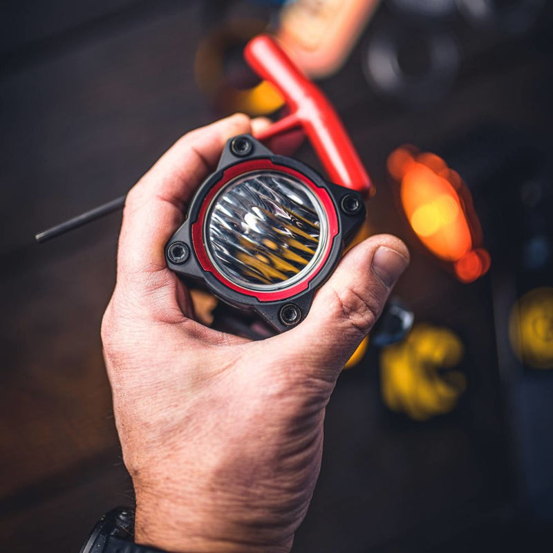 KC HiLiTES FLEX ERA 1 Bezel Ring, FLEX ERA 1 with a red bezel ring, held in hand
