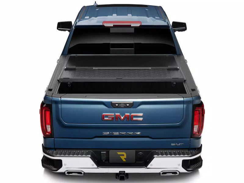 UnderCover Select hard folding tonneau cover part-open with the rear panel folded forward, straight rear view.