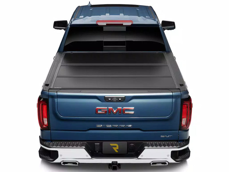 UnderCover Select hard folding tonneau cover closed and flush across the full bed width, straight rear view.