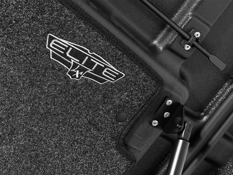 Close-up of the gray carpeted headliner under the lid, carrying the embroidered UnderCover Elite LX badge.