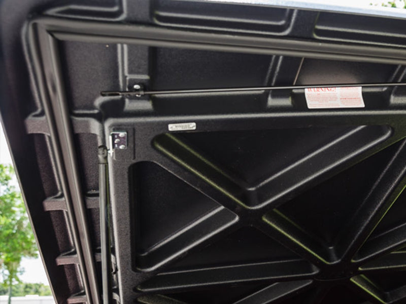 Close-up of the raised SE lid from below, showing the X-brace molding and the perimeter seal channel that runs around the edge.