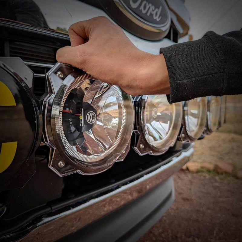 KC HiLiTES Gravity Titan & Pro6 6" Light Cover & Shield, hand fitting a clear shield onto a light bar