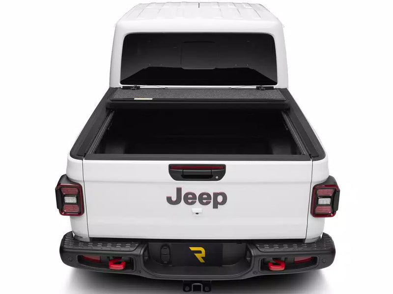 UnderCover Ultra Flex hard folding tonneau cover folded open and stacked against the bulkhead, straight rear view into the bed.