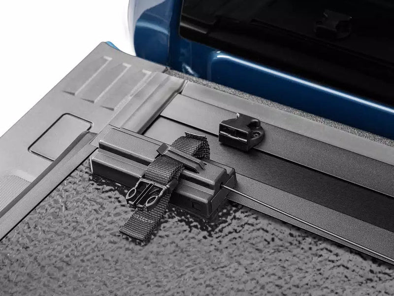 Close-up of the Select pull strap and buckle across the folded panel stack, with the latch catch on the rail.