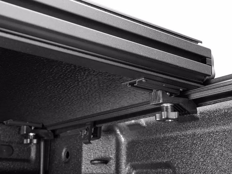 Close-up from inside the bed of the Select cover's side rail, mounting feet and clamp posts.