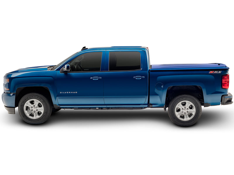 UnderCover LUX one-piece tonneau cover closed on a pickup bed, full side profile, the lid flush along the bed rail for the whole length of the box.