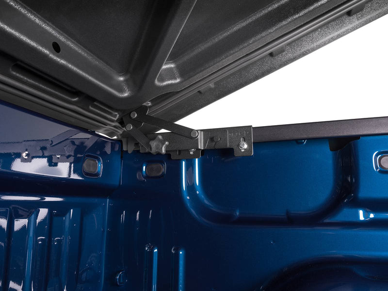 Close-up of the bare black textured underside of the raised LUX lid and the hinge mechanism at its forward edge.