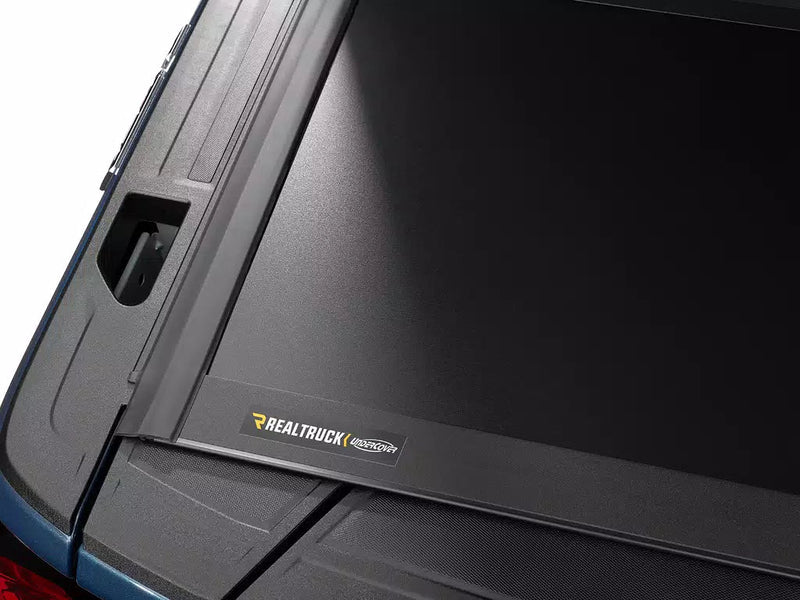 Close-up of the Select cover's rear edge and molded corner with the RealTruck UnderCover nameplate.