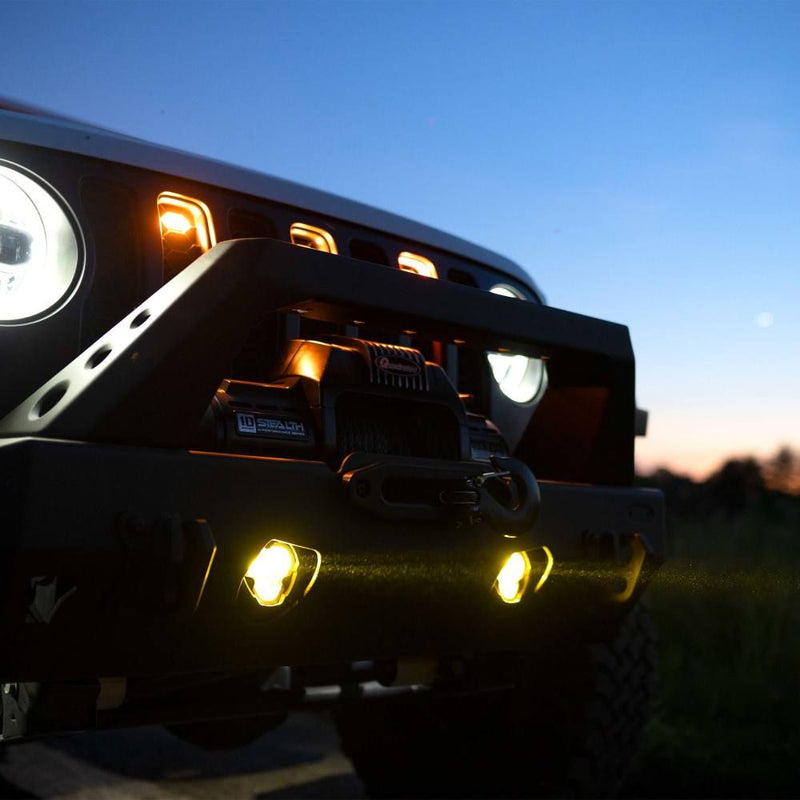 KC HiLiTES FLEX ERA 3 Dual-Mode SAE Fog Light Kit, Aftermarket Bumper, lit fog lights in a winch bumper at dusk