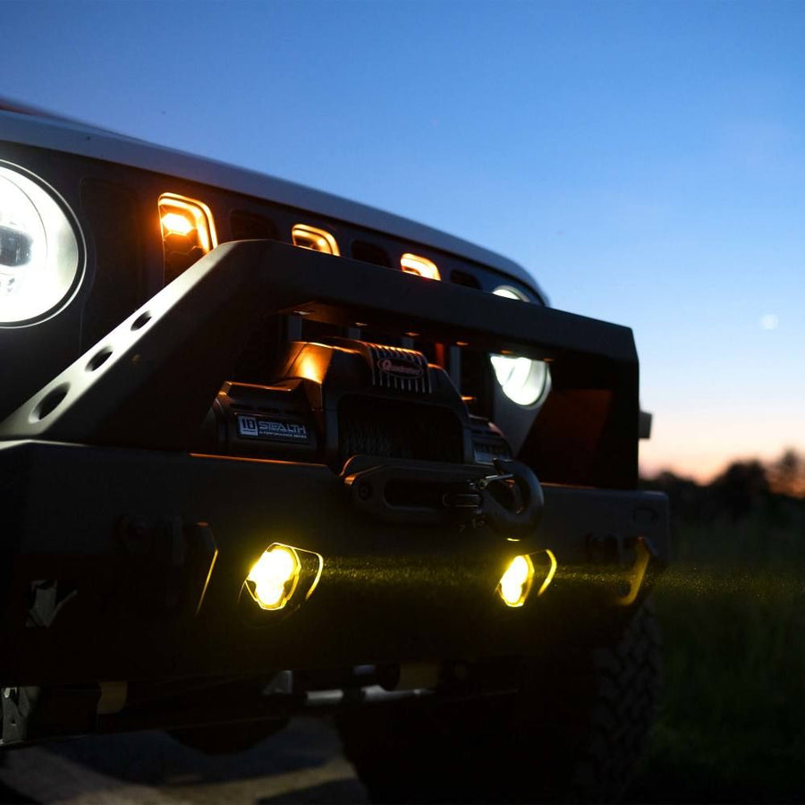 KC HiLiTES FLEX ERA 3 Dual-Mode SAE Fog Light Kit, Aftermarket Bumper, lit fog lights in a winch bumper at dusk