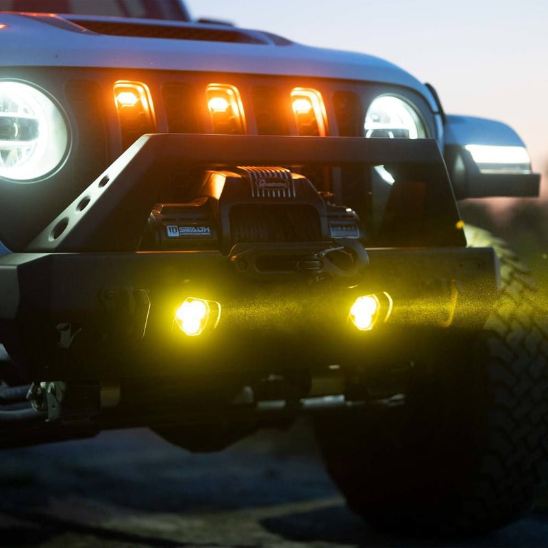 KC HiLiTES FLEX ERA 3 Dual-Mode SAE Fog Light Kit, Aftermarket Bumper, close-up of the lit fog lights in an aftermarket Jeep bumper