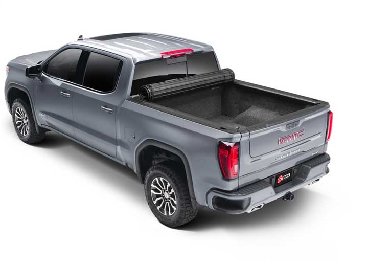 2019-2026 Chevrolet Silverado / GMC Sierra 1500 with the BAK Revolver X4s hard roll-up tonneau cover, rear three-quarter, cover rolled open
