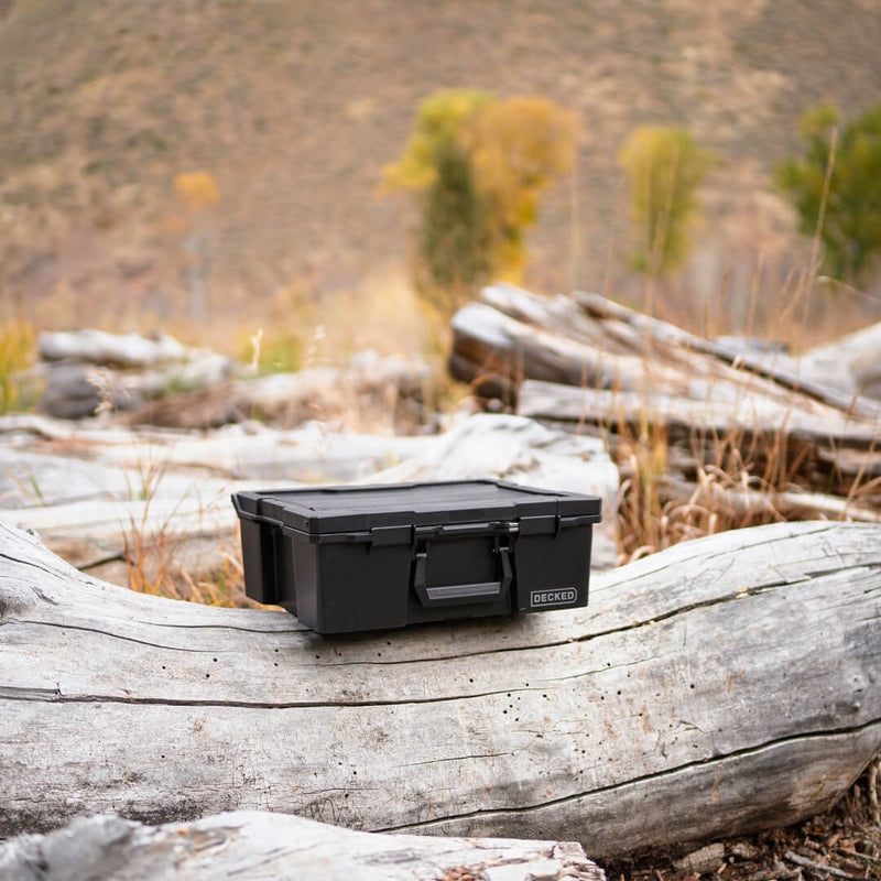 Black DECKED Halfrack 32 closed on a weathered log in high desert brush