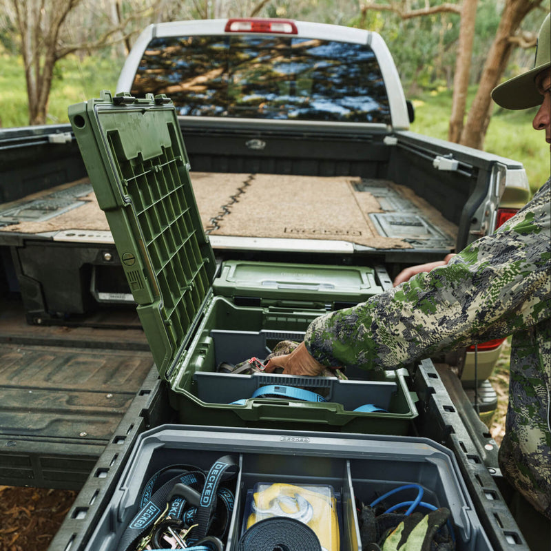 Ranger Green DECKED Halfrack 32 open in the drawer of a DECKED Drawer System while a hunter reaches inside