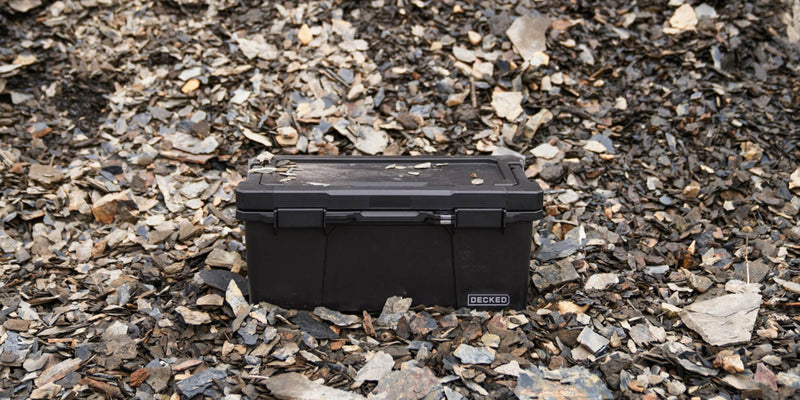 Black DECKED Sixer 16 sitting closed on dark shale rock outdoors