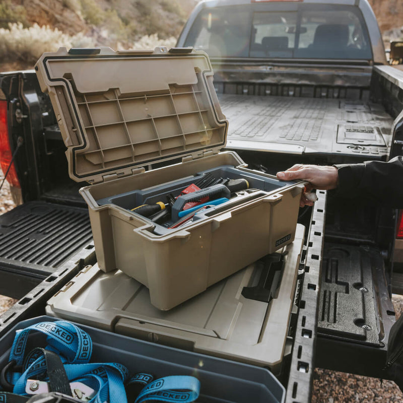 Desert Tan DECKED Sixer 16 open inside the drawer of a DECKED Drawer System in a pickup bed, gear in the tool tray