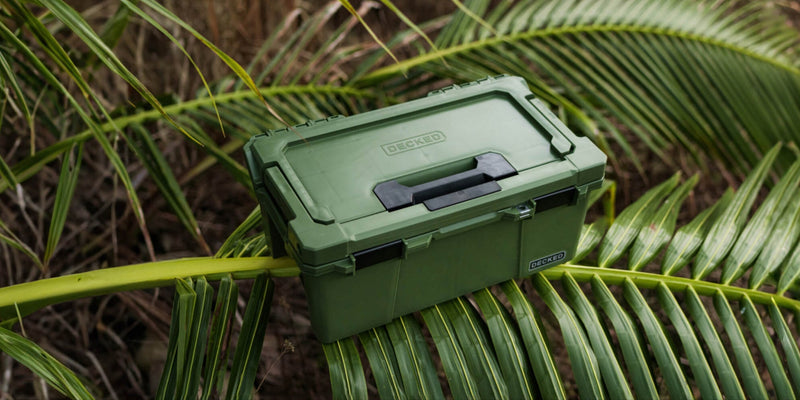 Ranger Green DECKED Sixer 16 closed, resting on palm fronds in tropical brush