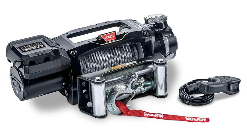 Warn ZEON XC 10 winch from an angle showing the low-profile control pack, steel wire rope on the drum and the roller fairlead