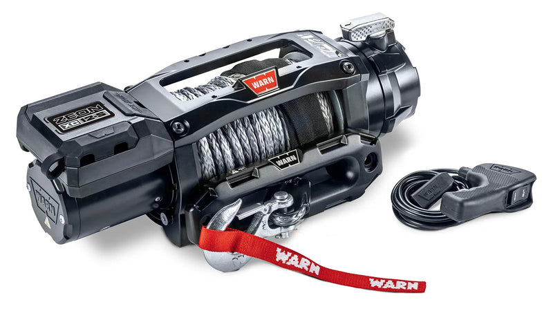 Warn ZEON XC 12-S winch from an angle showing the low-profile control pack, drum and clutch lever, with the corded remote alongside