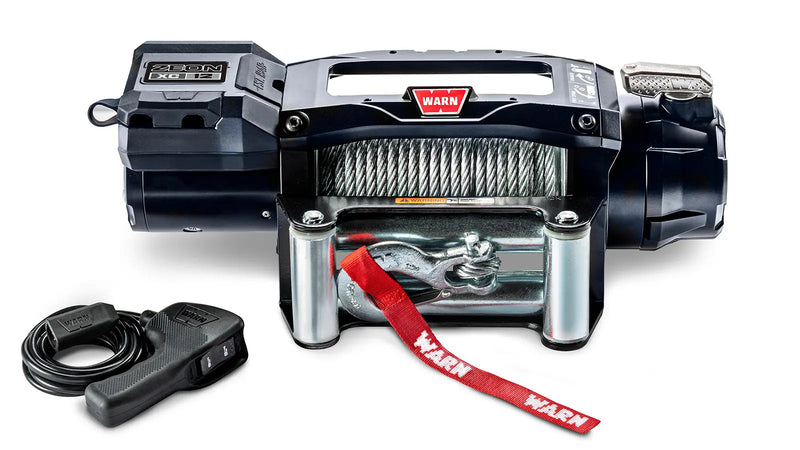 Warn ZEON XC 12 low-profile winch, front studio view with steel wire rope spooled, steel roller fairlead fitted and corded remote alongside