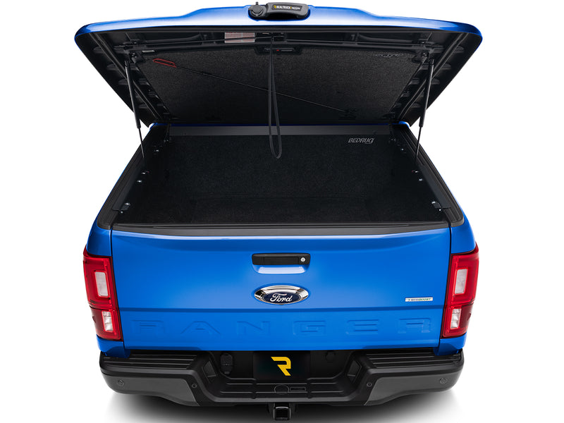 UnderCover Elite LX one-piece tonneau cover raised, straight rear view looking at the carpeted headliner with its Elite LX script and the lanyard pull strap hanging from it.