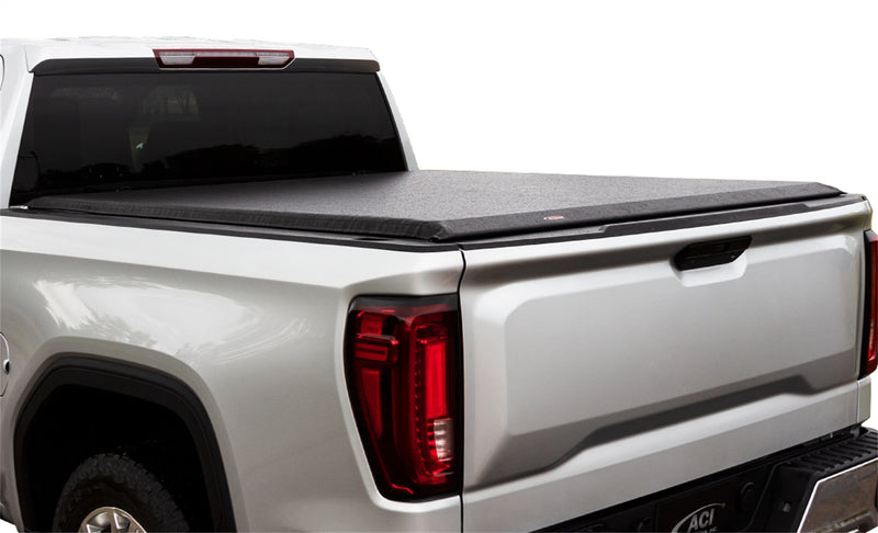 Full view of the Access Limited Edition roll-up tonneau cover: silver pickup on white with a black vinyl roll-up cover closed flat over the bed, rear three-quarter