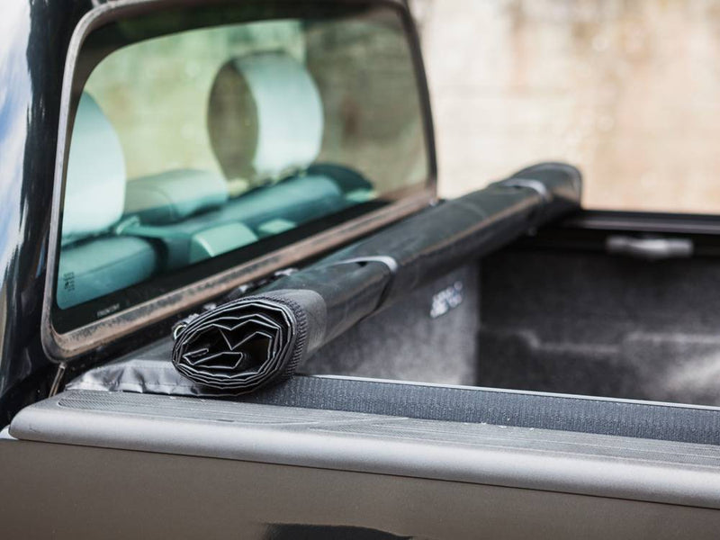 Cover rolled and strapped against the cab end of the bed