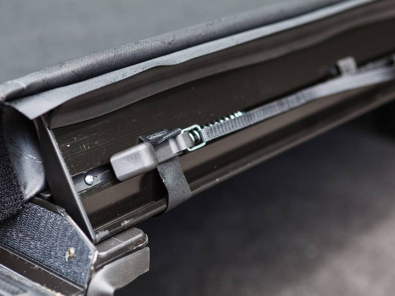 Close-up of the tension adjuster on the rear rail, cover lifted
