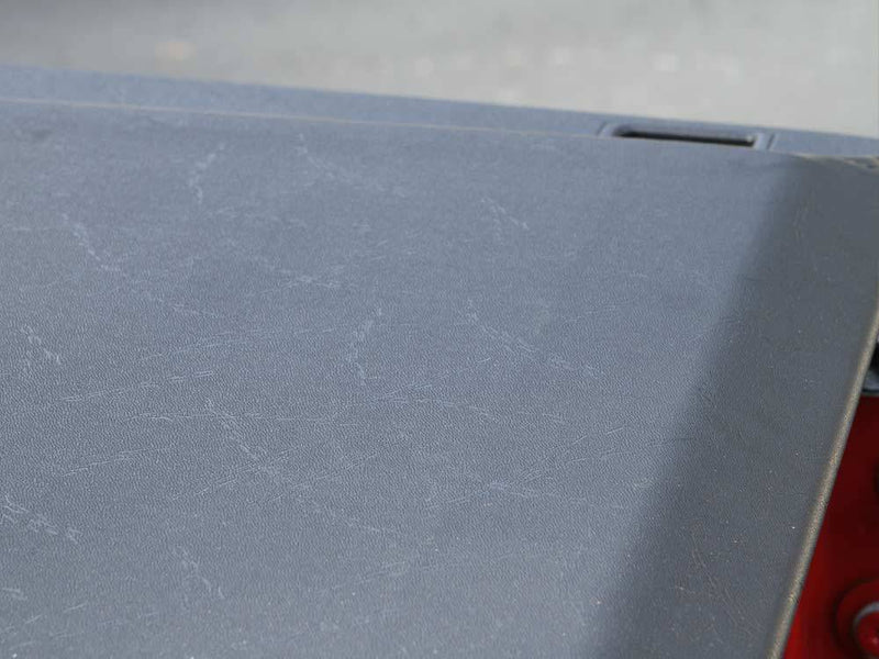 Close-up of the textured black vinyl surface of the closed cover at the bed rail