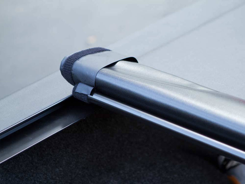 Rolled vinyl cover held in place by a hook-and-loop storage strap above the side rail