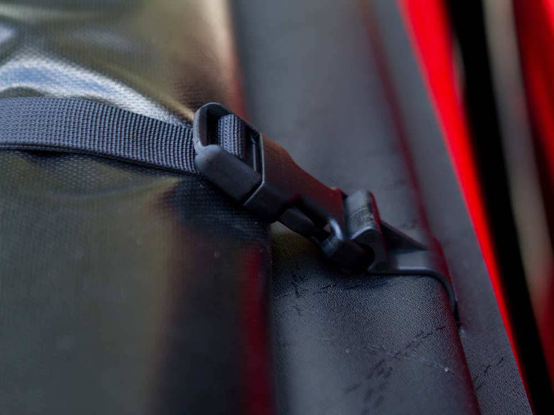 Nylon storage strap and black plastic buckle on the edge of the vinyl tarp